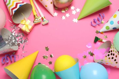 Parti şapkalarının çerçevesi ve pembe arka planda şenlikli dekorlar, düz yatış. Metin için boşluk