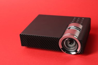 Kırmızı arkaplanda modern video projektörü, yakın plan