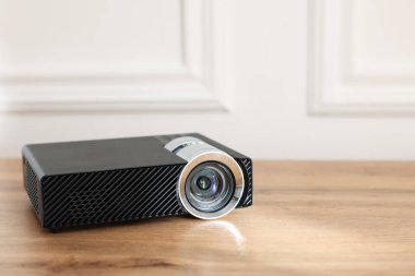 Modern video projektörü ahşap masada, yakın plan. Metin için boşluk