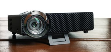 Beyaz arkaplana karşı ahşap tabloda modern video projektörü