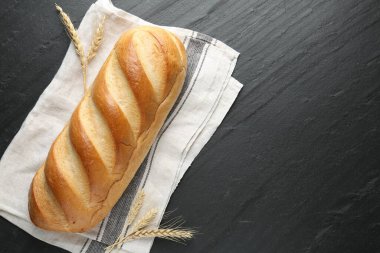 Siyah desenli masaya bir somun ekmek ve sivri uçlu çivi. Metin için boşluk