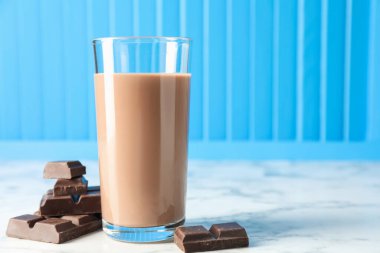 Bardakta çikolatalı süt ve beyaz mermer masada malzeme, yakın plan. Metin için boşluk