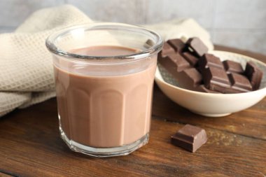 Bardakta çikolatalı süt ve ahşap masada malzeme, yakın plan.