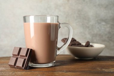 Cam bardakta çikolatalı süt ve ahşap masada malzeme.