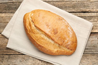 Ahşap masada bir somun ekmek, üst manzara.