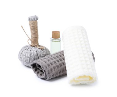 Temiz waffle havluları, masaj çantası ve beyaza izole edilmiş kozmetik ürünler.