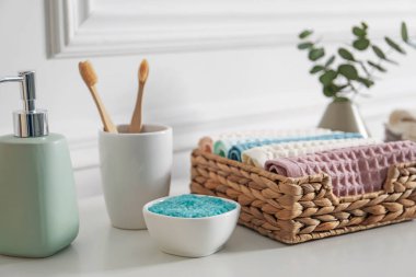 Temiz waffle havluları ve diğer banyo ürünleri banyodaki beyaz dolapta, yakın plan.