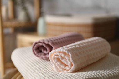 Banyodaki sandalyede temiz waffle havluları, yakın plan.