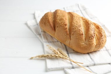 Taze ekmek somunu ve çiviler beyaz ahşap masada, yakın plan. Metin için boşluk