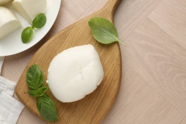 Ahşap masada mozzarella peyniri ve fesleğen var. Metin için boşluk