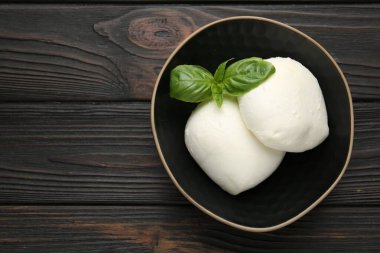 Ahşap masadaki fesleğen ve mozzarella peyniri parçaları, üst manzara. Metin için boşluk