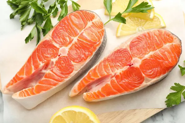 Deniz ürünleri. Taze çiğ somon bifteği, maydanoz ve bir dilim limon.