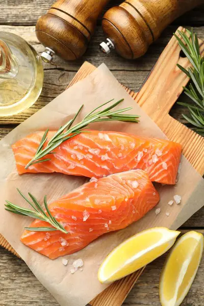 Deniz ürünleri. Somon fileto, baharat, yağ ve limon dilimleri ahşap masa üzerinde, düz yatıyordu.