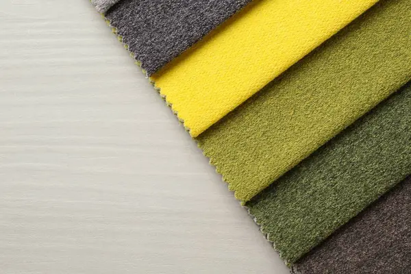 Açık ahşap masadaki farklı kumaşlardan örnekler, üst manzara. Metin için boşluk