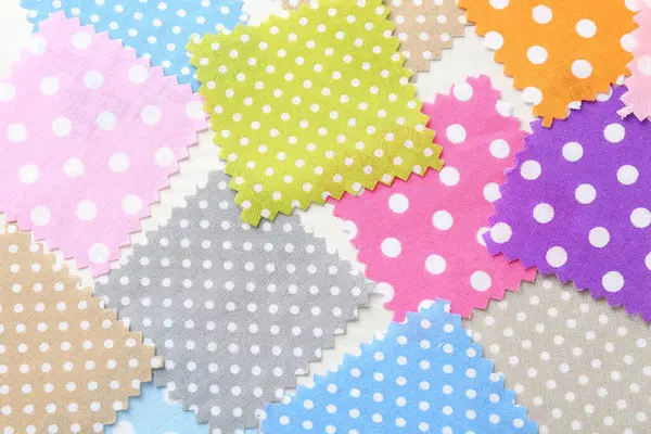 Beyaz ahşap masa üzerinde farklı kumaş örnekleri, düz yatıyordu.