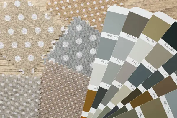 Renkli kumaş örnekleri ve renk paletleri ahşap masa üzerinde, düz yatıyordu