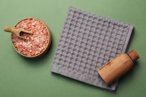 Yeşil zemin üzerinde temiz waffle havlusu ve kozmetik ürünleri, düz yatıyordu.