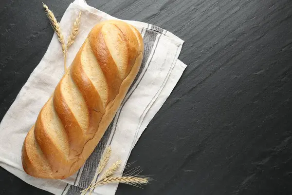 Siyah desenli masaya bir somun ekmek ve sivri uçlu çivi. Metin için boşluk