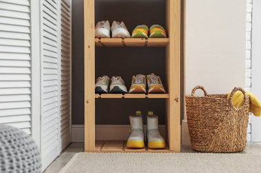 Girişteki raflarda farklı ayakkabılar var. Ayakkabı deposu