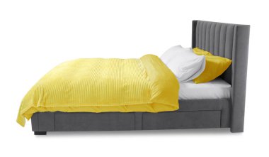 Beyaz arka planda güzel çarşaflarla yapılmış bir yatak.