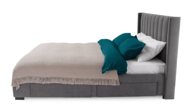 Beyaz arka planda güzel çarşaflarla yapılmış bir yatak.