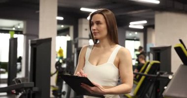 Spor merkezinde panosu olan kişisel antrenör.