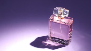 Menekşe arka planda parfüm şişesi, mesaj için boşluk. Işığın yönü değiştiriliyor