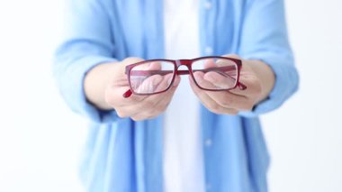 Beyaz arkaplanda bir çift gözlük gösteren kadın, yakın plan