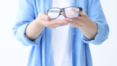 Beyaz arkaplanda bir çift gözlük gösteren kadın, yakın plan