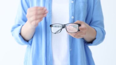 Beyaz arkaplanda bir çift gözlük gösteren kadın, yakın plan