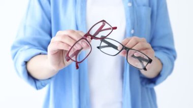 Beyaz arkaplanda çift gözlük gösteren kadın, yakın plan