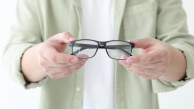 Beyaz arkaplanda bir çift gözlük gösteren kadın, yakın plan