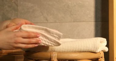 Kadınlar banyodaki sandalyelere katlayıp temiz havlular koyuyorlar.