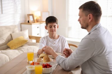 Baba ve oğul akşam yemeğinden önce evde dua ediyorlar.