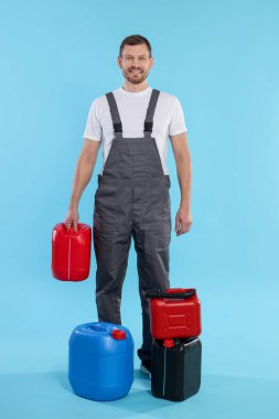 Açık mavi arka planda plastik kutuları olan bir adam.