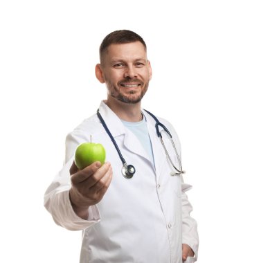 Beyaz arka planda yeşil elmalı ve steteskoplu beslenme uzmanı.