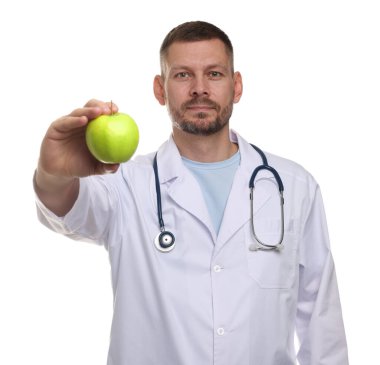 Beyaz arka planda yeşil elmalı ve steteskoplu beslenme uzmanı.