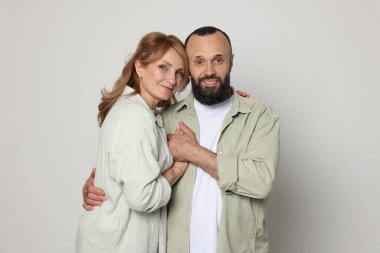 Açık gri arka planda sevimli bir çiftin portresi