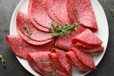 Gri masada servis edilen kekik dilimli lezzetli sosisler.