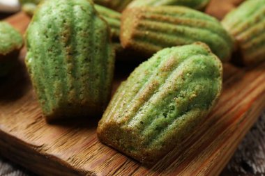 Lezzetli Matcha Madeleine kekleri ahşap masada, yakın plan.