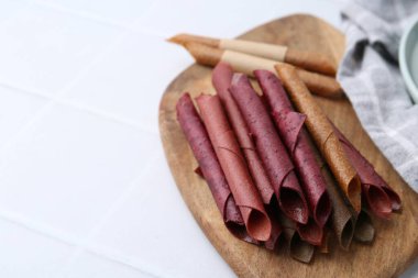 Beyaz fayanslı masada leziz meyveli deri rulo, yakın plan. Metin için boşluk