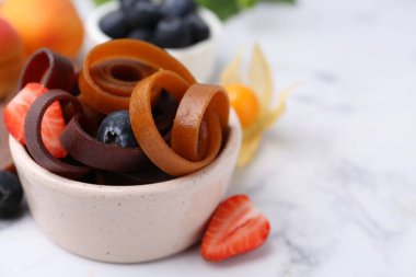 Lezzetli meyve derisi kase içinde yuvarlanıyor ve beyaz mermer masada böğürtlenler, yakın plan. Metin için boşluk