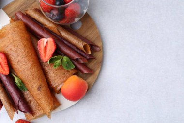 Lezzetli meyve dürümleri, nane ve böğürtlenler ışık masasında, üst manzara. Metin için boşluk