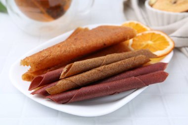 Lezzetli meyve dürümleri beyaz masada, yakın plan.