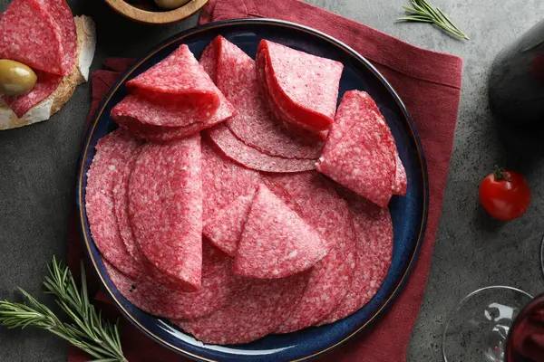 Gri masada servis edilen leziz sosis dilimleri.