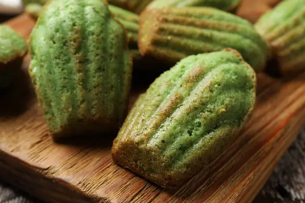 Lezzetli Matcha Madeleine kekleri ahşap masada, yakın plan.
