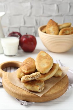 Lezzetli kızarmış pirinçler (doldurulmuş turtalar) ve beyaz ahşap masada elmalar, yakın plan.