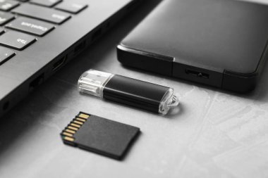 Flaş bellek, SD hafıza kartı, harici sabit disk ve dizüstü bilgisayar gri desenli tablo, yakın plan