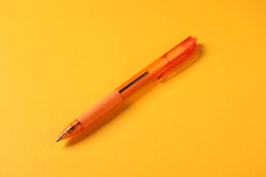 Turuncu arka planda şık bir kalem, yakın plan.