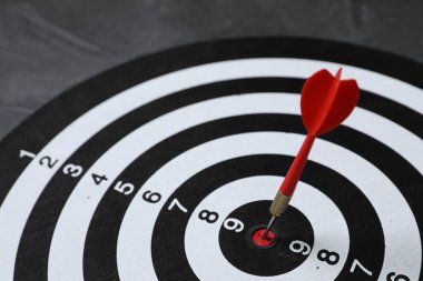 Hedef alınıyor. Gri arkaplanlı oklu dart tahtası, yakın plan